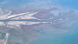 Aerial view of a braided river flowing into the sea.
