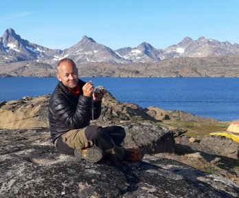 Richard Philips in Greenland, sitting on a rock