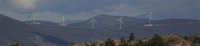 Five wind turbines in a mountainous landscape. 