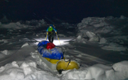 Børge Ousland pulling a sled with supplies in the dark through an icy, snowcovered landscape.