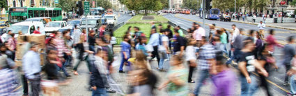 People in motion crossing a busy street.