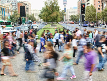 People in motion crossing a busy street.