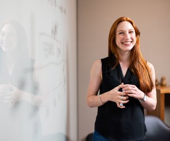 A teacher standing by a whiteboard