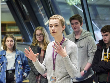 Person giving a talk to students in areading room.