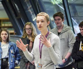 Person giving a talk to students in areading room.