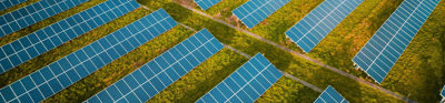 Vast solar panel farm on grass as seen from above.