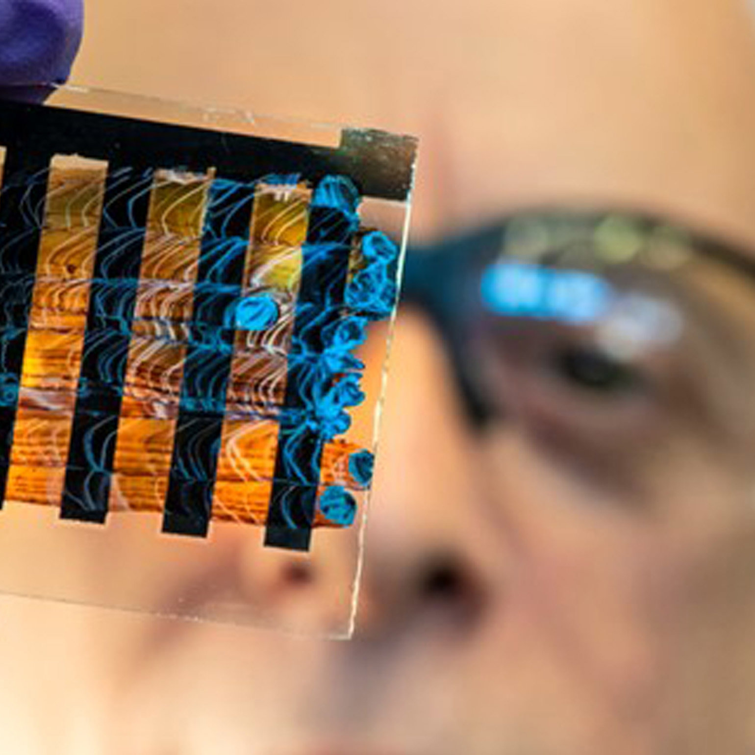 A person holding up a component from a solar panel