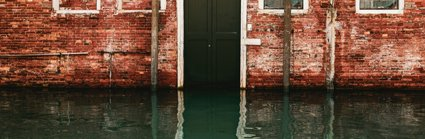 Flood water rising in front of a black front door