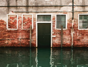 Flood water rising in front of a black front door
