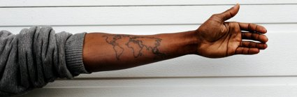 An arm with a tattoo of a map of the world.