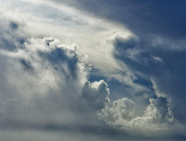 Moody grey clouds forming over the sea - you can see light bouncing off the edges of the clouds