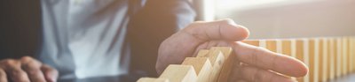 Person's hand over a set of dominoes