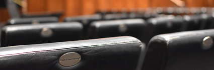 A close up of black leather chairs in a lecture hall. 