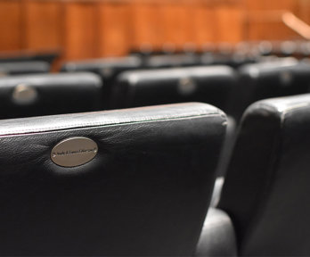 A close up of black leather chairs in a lecture hall. 