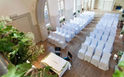 White chairs setup for a wedding ceremony looking down from the mezzanine in the Main Hall.