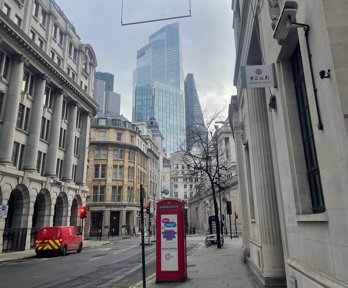 Image of London financial district in the day. Skyscrapers and a phone box can be seen