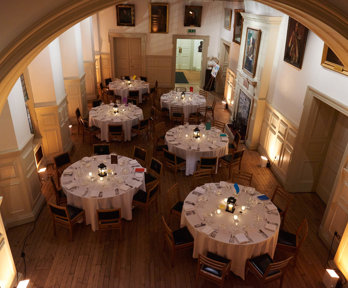 Six large round tables set for a formal dinner.