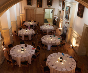 Six large round tables set for a formal dinner.