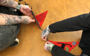 Two people who are sitting on a floor creating decorative flags.