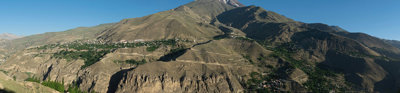 A wide-lens angle view of a mountain with a small town below.