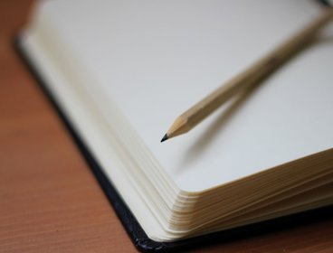 Open notebook with a pencil on top