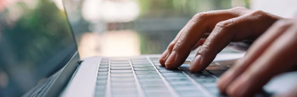 Closeup image of a person typing on laptop computer keyboard.