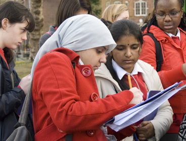 Two female students looking together at a clipboard