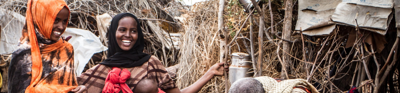 Group of people with straw and stick structures behind them