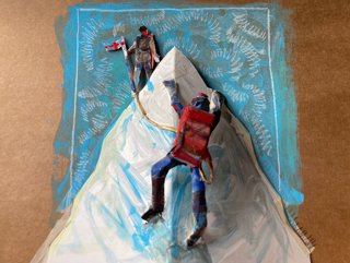 A paper model of Everest with two men climbing, one going up and one at the top