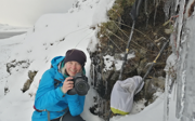 Phoebe Smith holding a camera in icy environment. 