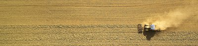 An aerial view of two harvesters ploughing a field of wheat