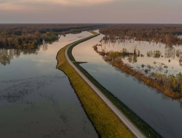 A levee on a river bank that has burst its banks