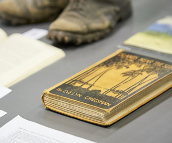 Display of historic materials including worn boots and books.