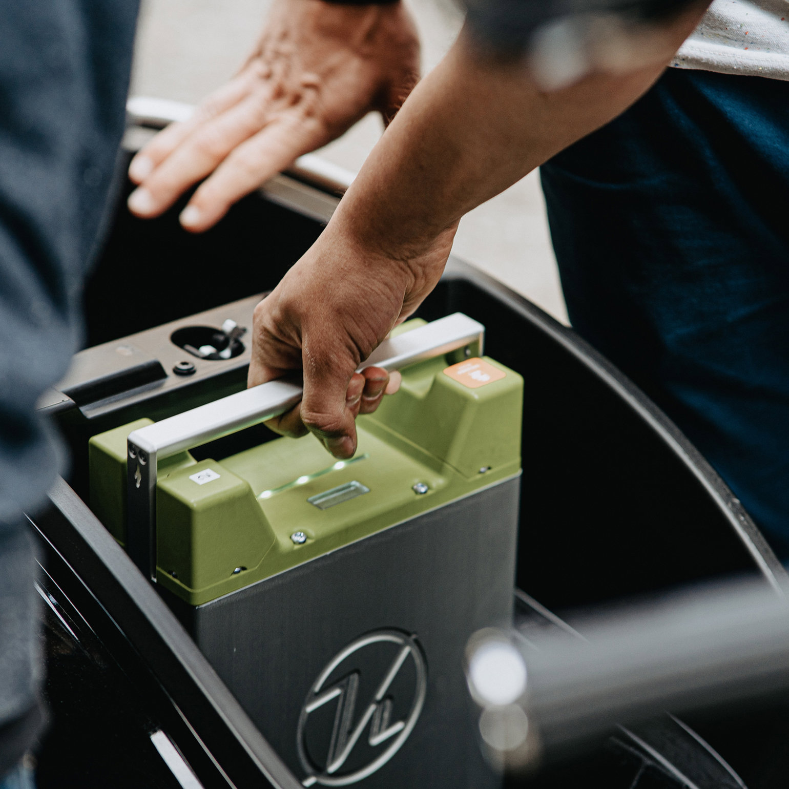 A person handling a large electric battery