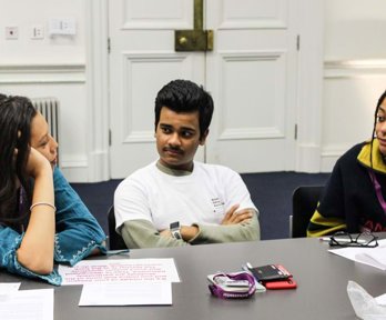 A group of university students sitting at a table talking about being a geography ambassador