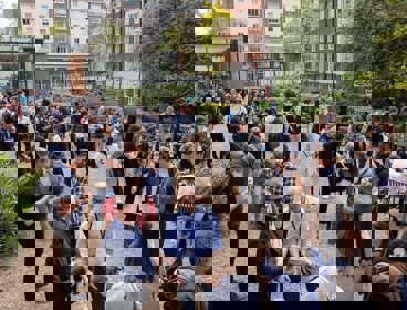 Large group of people networking on outdoor terrace of Royal Geographical Society in London.