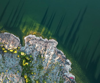 Ariel view of rocky land at water's edge and body of water.