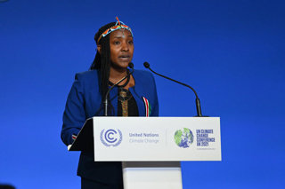 Woman standing at lectern talking at a conference