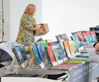 A person browsing a table of books.