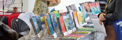 A person browsing a table of books.