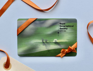 A plastic membership card featuring a green landscape sits on a blue background with orange ribbon wrapped around it.