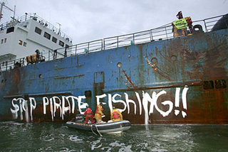 Protest groups such as Greenpeace (here seen stopping an illegal fishing boat offloading its cargo) have a role to play in ocean governance.