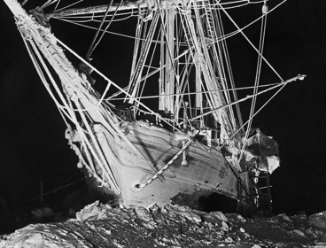 Black and white photograph taken by Frank Hurley of the Endurance trapped in the ice. Photography titled The Long, Long Night. 