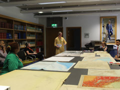 Dr Alice Oates gives a talk in the Foyle Reading Room during the map room conversations, she is showing the audience various maps on the table