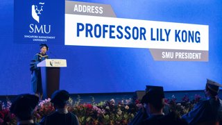 Professor addressing graduates at their graduation ceremony on campus.