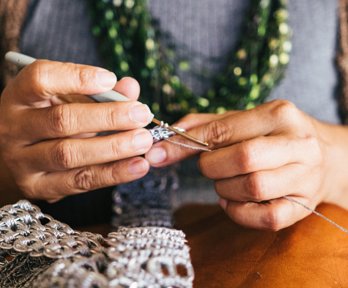 Person holding a crochet hook and crocheting. 