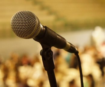 Microphone on stand in front of a crowd of people