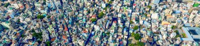 Aerial view of city with colourful buildings next to an ocean. 