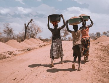 African women carrying bowls of grain on their heads
