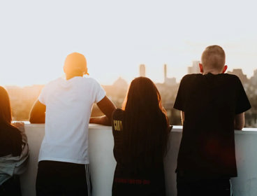 Four young people looking at a city view with their backs to the camera.